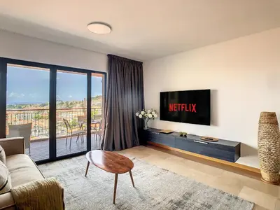 a living room with a couch and a tv at Arigato Apartment by LovelyStay in Funchal