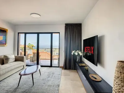 a living room with a couch and a tv at Arigato Apartment by LovelyStay in Funchal