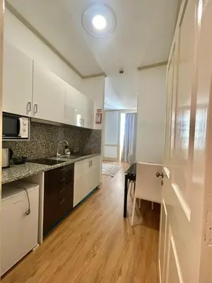 a kitchen with white cabinets and a table and a sink at Carreira Apartments Harbour View Free Parking in Heart Funchal in Funchal