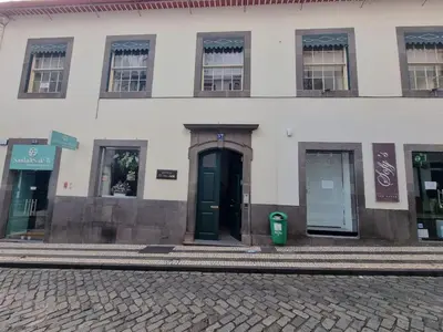 a white building with a black door on a street at Carreira Apartments Harbour View Free Parking in Heart Funchal in Funchal