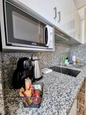 a kitchen counter with a microwave and a basket of food at Carreira Apartments Harbour View Free Parking in Heart Funchal in Funchal