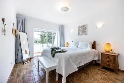 a white bedroom with a bed and a window at CoolHouses Luz, 3 Bed linked house, shared pool, a stone's throw of the sea, Casa Sirrah in Luz