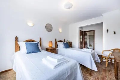a bedroom with two beds with blue pillows at CoolHouses Luz, 3 Bed linked house, shared pool, a stone's throw of the sea, Casa Sirrah in Luz
