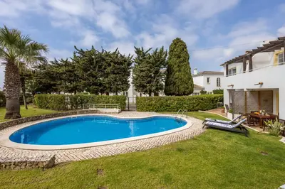 a swimming pool in the yard of a house at CoolHouses Luz, 3 Bed linked house, shared pool, a stone's throw of the sea, Casa Sirrah in Luz