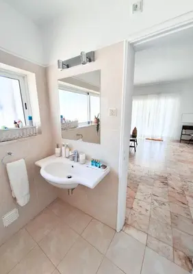 a white bathroom with a sink and a mirror at Casa Oceanis in Salema