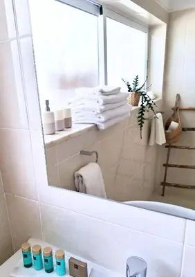 a bathroom with a mirror over a bath tub at Casa Oceanis in Salema