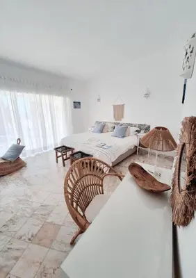 a large white room with two beds and chairs at Casa Oceanis in Salema