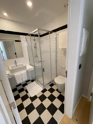 a bedroom with a bed and a table and a television at PIER HOUSE Accommodation in Funchal