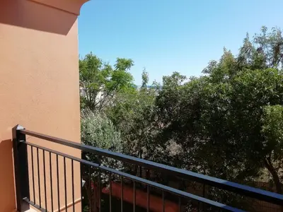 a balcony with a black railing and trees at Sunny Retreat in Luz