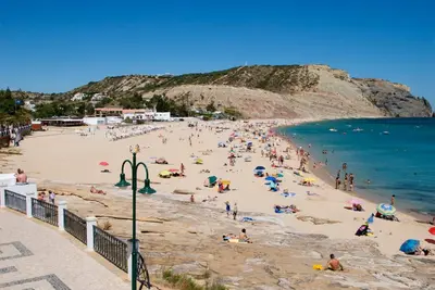 a group of people on a beach near the water at Sunny Retreat in Luz
