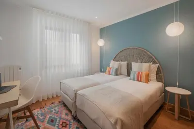a bedroom with a large bed and a desk at Lido View Calla by An Island Apart in Funchal