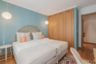 a bedroom with a large bed and a blue wall at Lido View Calla by An Island Apart in Funchal