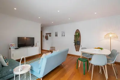 a living room with a blue couch and a table at Lido View Calla by An Island Apart in Funchal