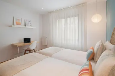 a white bedroom with a bed and a desk at Lido View Calla by An Island Apart in Funchal