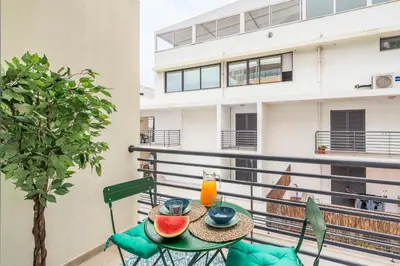 a table with fruit on a balcony with a building at Lido View Calla by An Island Apart in Funchal