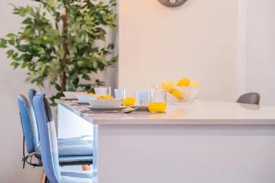 a table with bowls of fruit and glasses of orange juice at Caniço Penthouse by Homie in Santa Cruz
