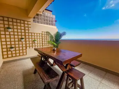 a dining room with a table and a view of the ocean at Caniço Penthouse by Homie in Santa Cruz