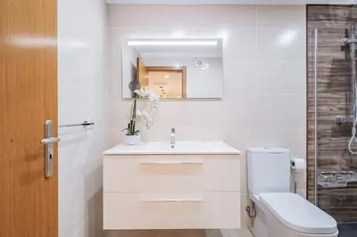 a bathroom with a toilet and a sink and a mirror at Caniço Penthouse by Homie in Santa Cruz