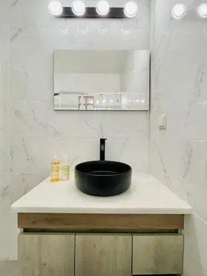 a bathroom with a black sink and a mirror at Apartamento Maria Fernanda, in the Centre of Luz in Luz