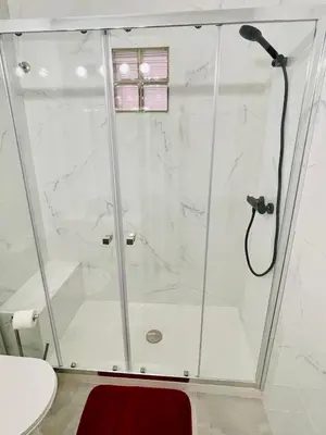 a shower in a bathroom with a glass shower stall at Apartamento Maria Fernanda, in the Centre of Luz in Luz