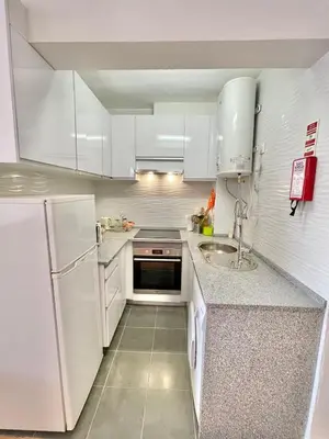 a white kitchen with a sink and a refrigerator at Apartamento Maria Fernanda, in the Centre of Luz in Luz