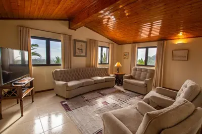 a living room with couches and a tv at A House With a View in Aljezur