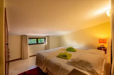 a bedroom with a bed with green pillows on it at A House With a View in Aljezur