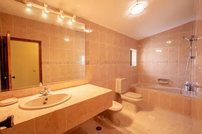 a bathroom with a sink and a toilet and a mirror at A House With a View in Aljezur
