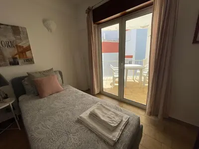 a bedroom with a bed and a door to a patio at M&M's Cosy apartment - Sea view in Luz
