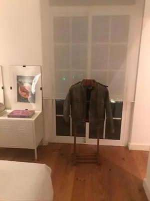 a jacket on a stand in a room with a window at City center boutique apartment in Funchal