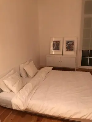 a large white bed in a room with two windows at City center boutique apartment in Funchal