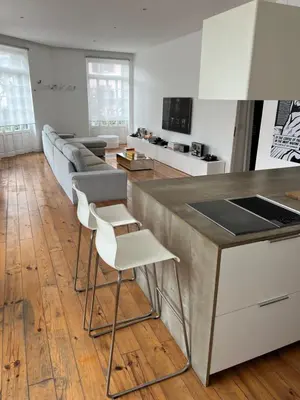 a kitchen and living room with a counter and chairs at City center boutique apartment in Funchal