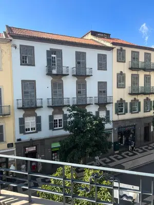 a large white building with balconies on a street at City center boutique apartment in Funchal
