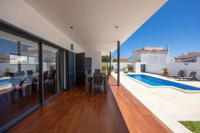 an open living room with a swimming pool and a house at Pontalaia Village in Sagres