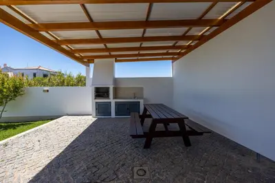 a patio with a picnic table and a wooden roof at Pontalaia Village in Sagres