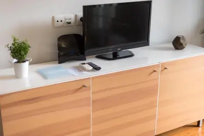 a tv on top of a dresser with a desk at Apartamentos Santa Maria by Heart of Funchal in Funchal