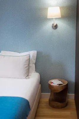 a bedroom with a bed and a lamp on a wall at Apartamentos Santa Maria by Heart of Funchal in Funchal