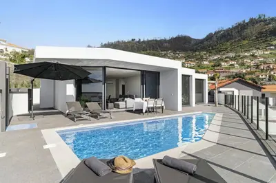 a villa with a swimming pool and a house at Villa Calheta Charm by Villa Plus in Arco da Calheta