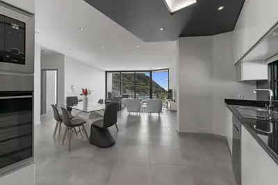 a kitchen and dining room with a table and chairs at Villa Calheta Charm by Villa Plus in Arco da Calheta