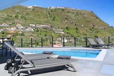 a swimming pool with a mountain in the background at Villa Calheta Charm by Villa Plus in Arco da Calheta