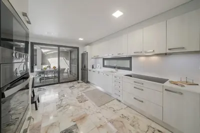 a kitchen with white cabinets and a marble floor at Villa Old Town by Villa Plus in Funchal