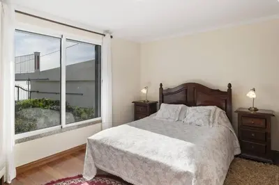 a bedroom with a bed and a large window at Villa Theos House by Villa Plus in Fajã da Ovelha
