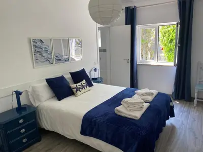 a blue couch in a living room with a window at Casa La Isla in Sagres