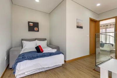 a bedroom with a bed with a blue blanket at Casa da Praia, 2min de la PLAGE, hyper centre in Machico