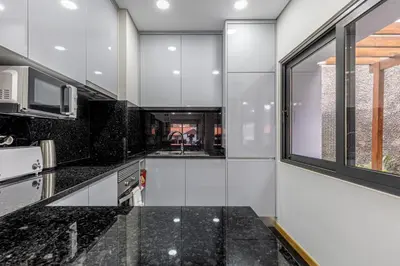 a kitchen with black granite counter tops and a window at Casa da Praia, 2min de la PLAGE, hyper centre in Machico