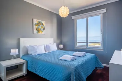 a bedroom with a blue bed with a window at Canico Vip Lodging by Homie in Santa Cruz