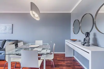 a dining room with a glass table and mirrors at Canico Vip Lodging by Homie in Santa Cruz