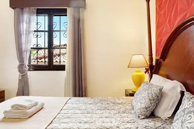 a bedroom with a bed with a window and a lamp at Suites Pinto Coelho in Caniço