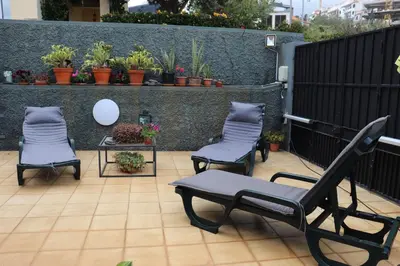 a patio with three chairs and a table and a fence at Suites Pinto Coelho in Caniço