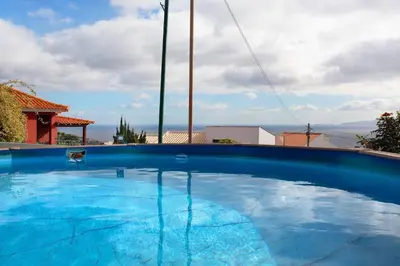 a large blue swimming pool on top of a house at Suites Pinto Coelho in Caniço